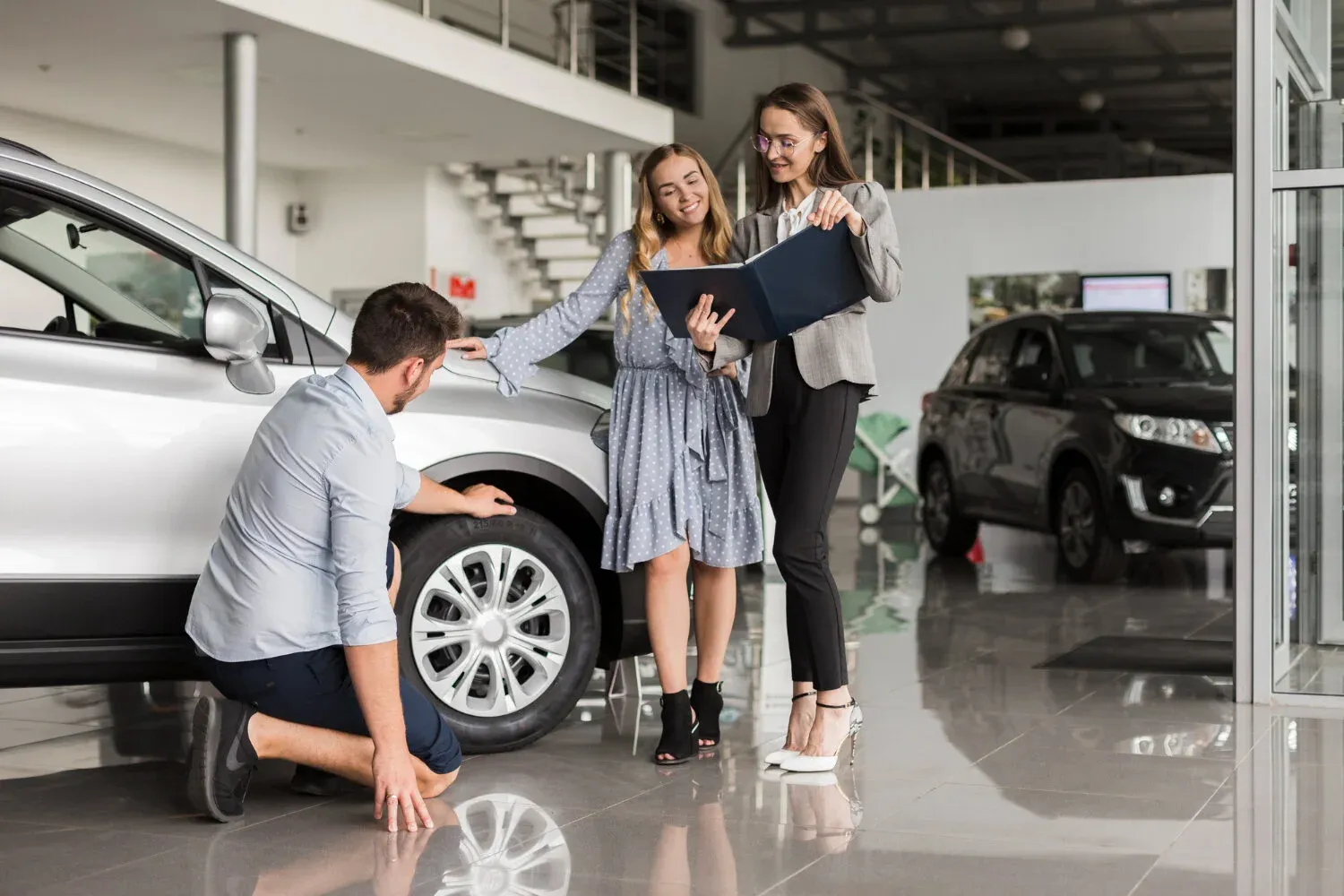 Couple examining a car at a dealership