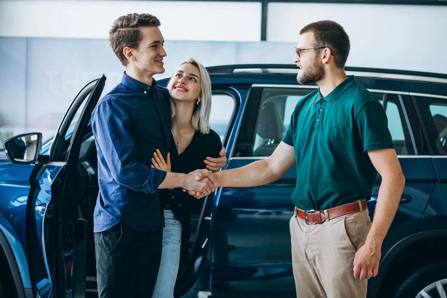 Young couple buying a car from a sales rep